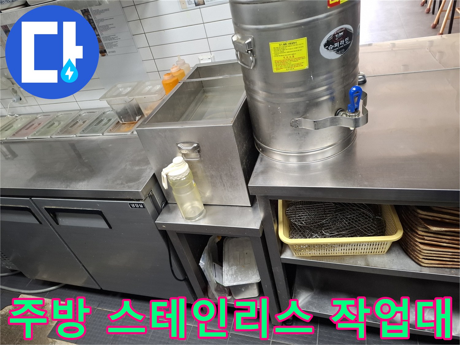 스테인리스 재질의 주방 조리대와 배수 설비 주변 모습입니다.
