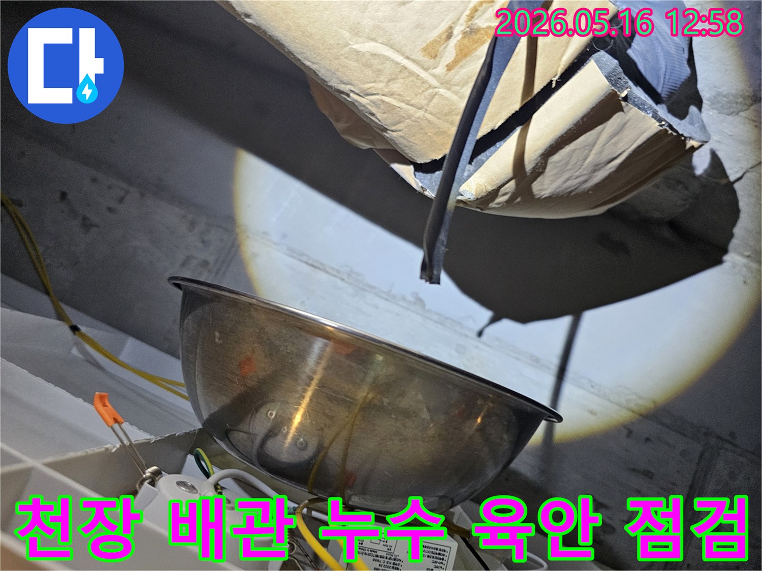 주택 천장 내부의-배관 상태를-밝은 조명으로 비춰-육안으로 누수 여부를-점검하는 모습입니다
