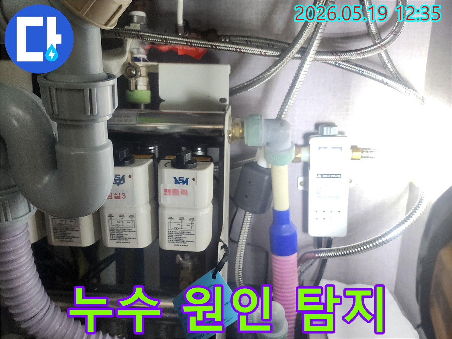 누수 원인을-찾기 위해-복잡하게 얽힌-배관 시스템과-정수 장치를-전문가가-꼼꼼하게-점검하는-현장 사진입니다.