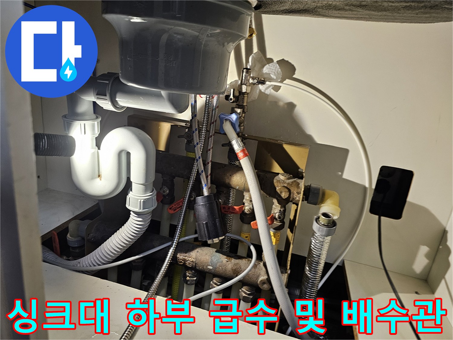 싱크대 아래쪽의 복잡한 배관과 연결 부위 상세 모습