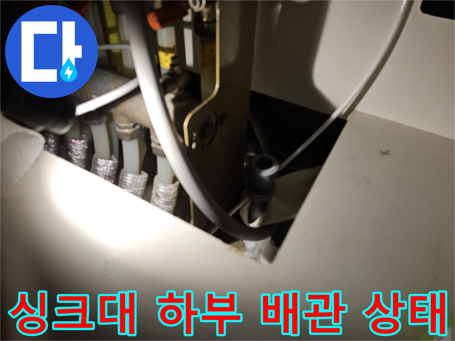 싱크대-하부장-내부-배관-연결-부위-점검-중인-모습