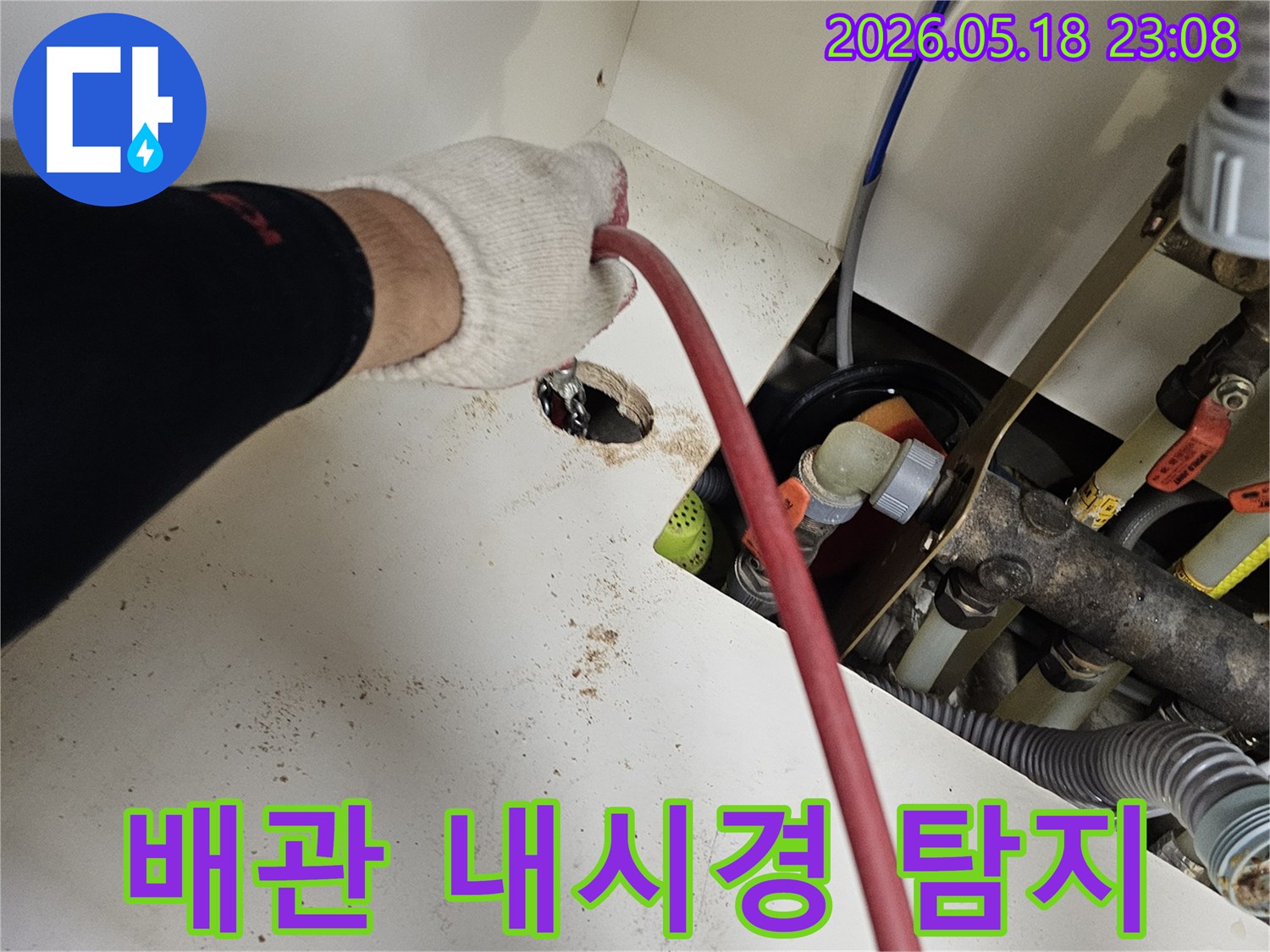 전문가가-작업용-장갑을-끼고-배관-내부-탐지용-내시경-케이블을-삽입하는-모습