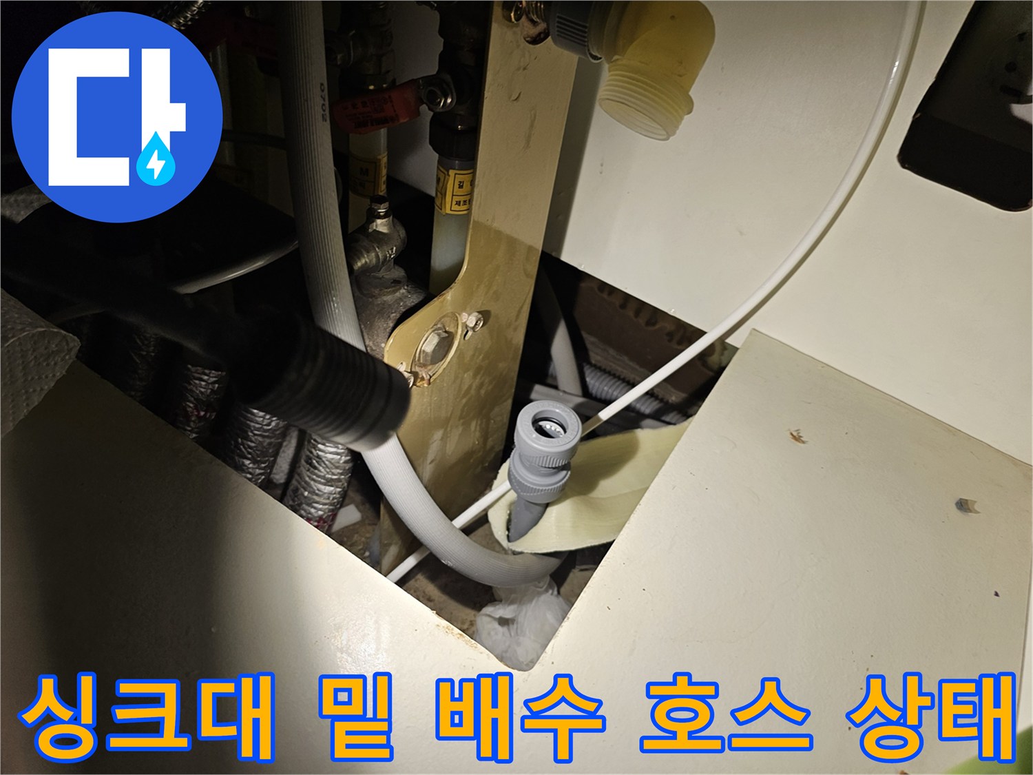 하부장 내부의 배수 배관과 연결 부속품들의 배치 모습