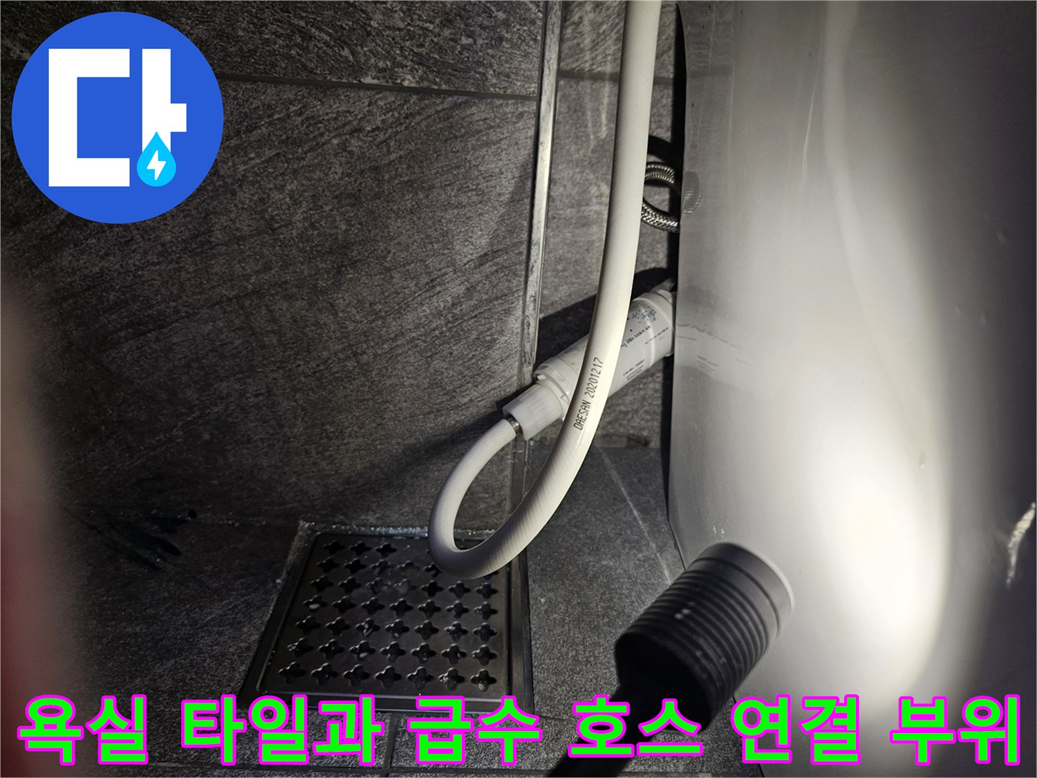 변기 옆 급수 라인과 배수구 격자 덮개 근접 촬영