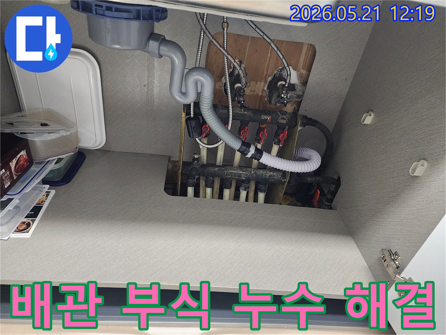 싱크대 하부의 부식된 배관-누수 문제 해결을 위해 점검 중인 현장 사진입니다.