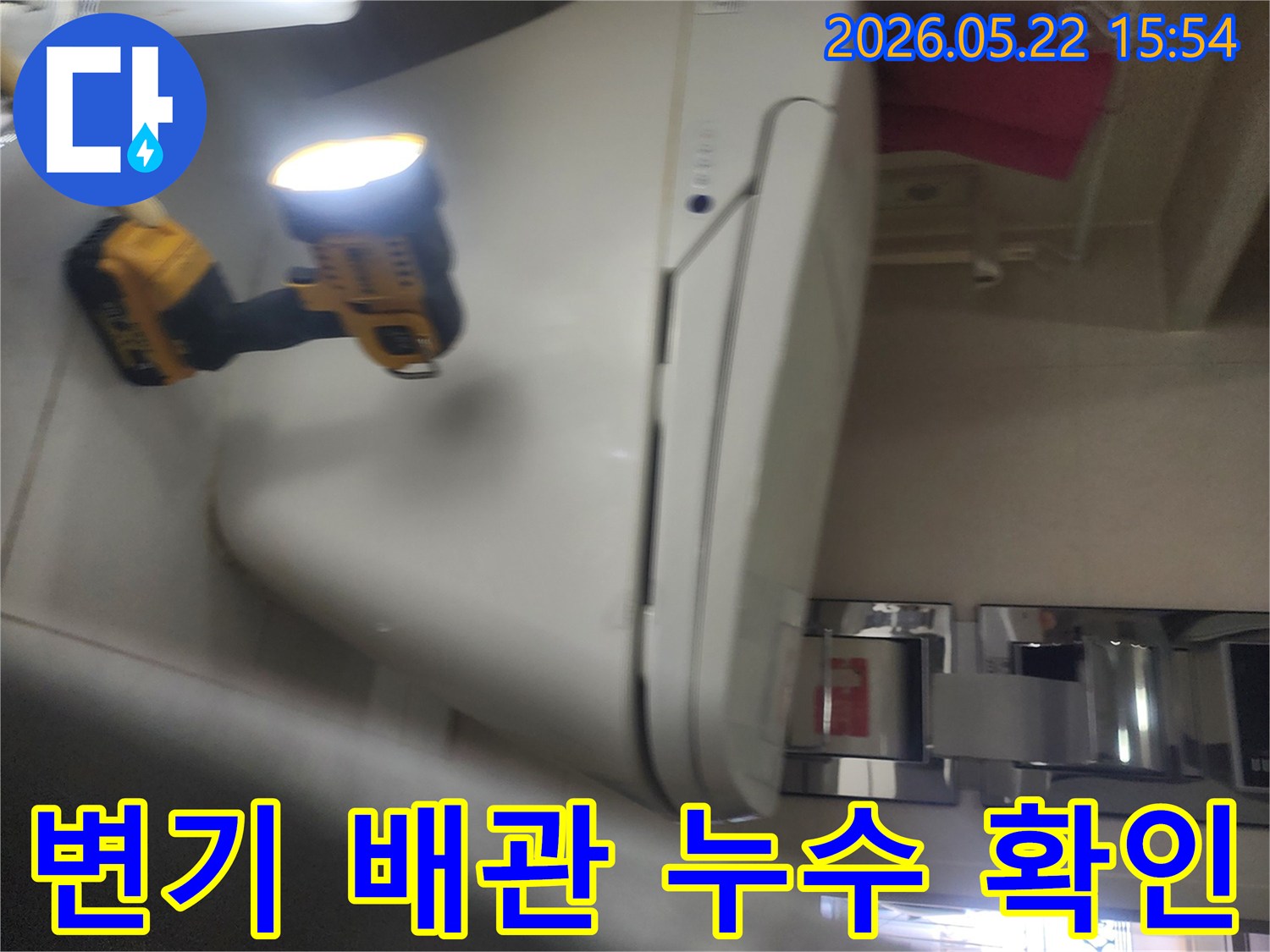 기흥구 화장실에서-변기 배관 누수 여부를-확인하기 위해-작업등을 사용해-세밀하게 점검하는-누수 전문가의 작업 현장