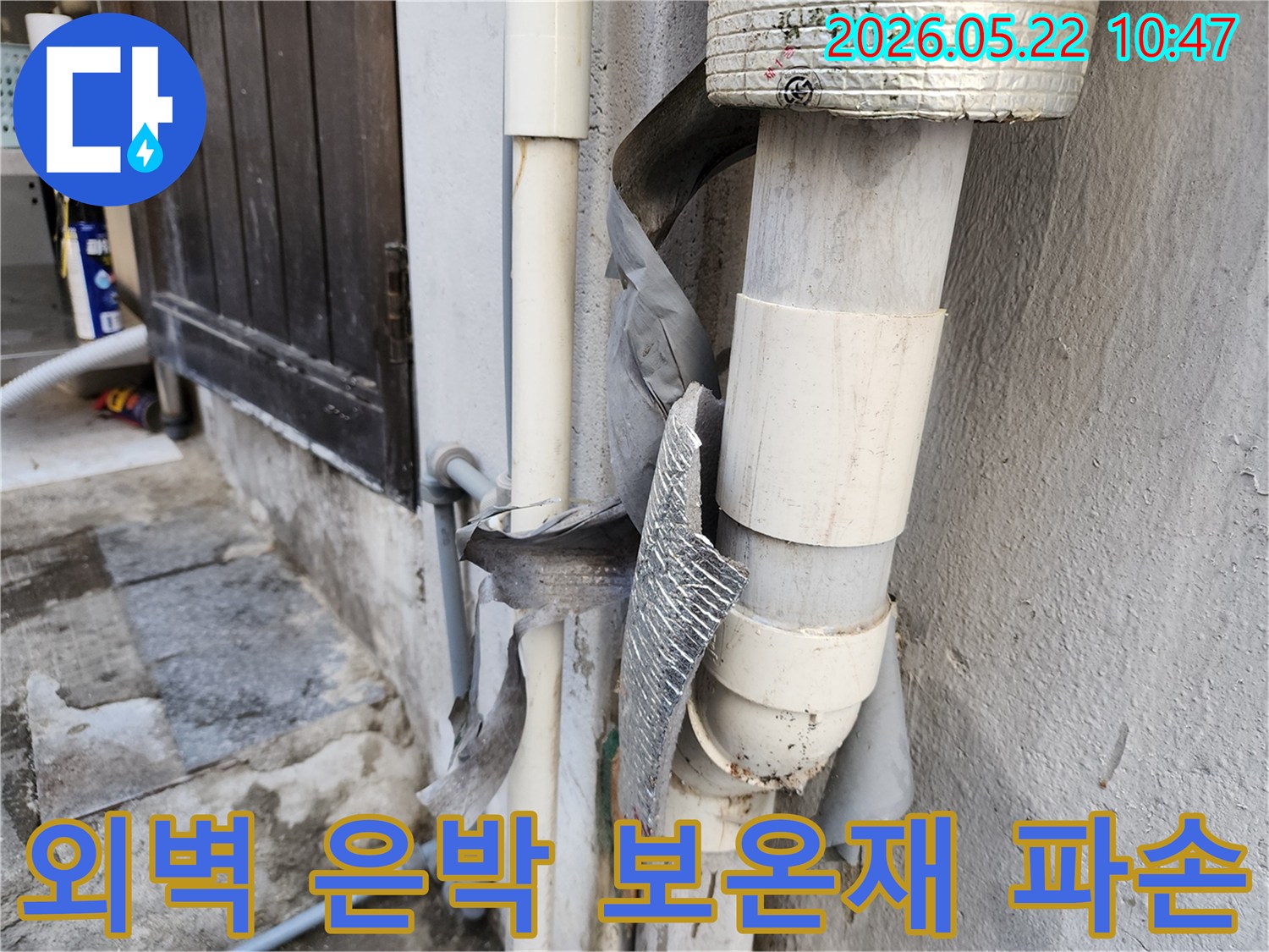 건물 외벽 배관에 사용된 은박 보온재가-찢어지고 벗겨져-단열 기능을 완전히 상실한 모습입니다.