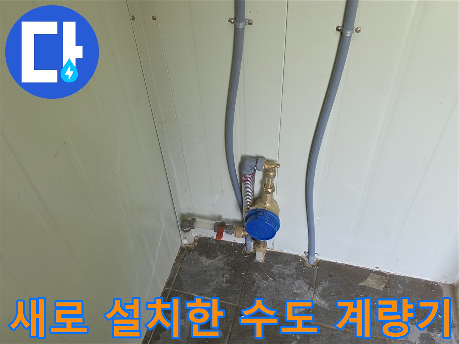 화장실 벽면에 새로 설치된 파란색 수도 계량기와 배관 연결 상태