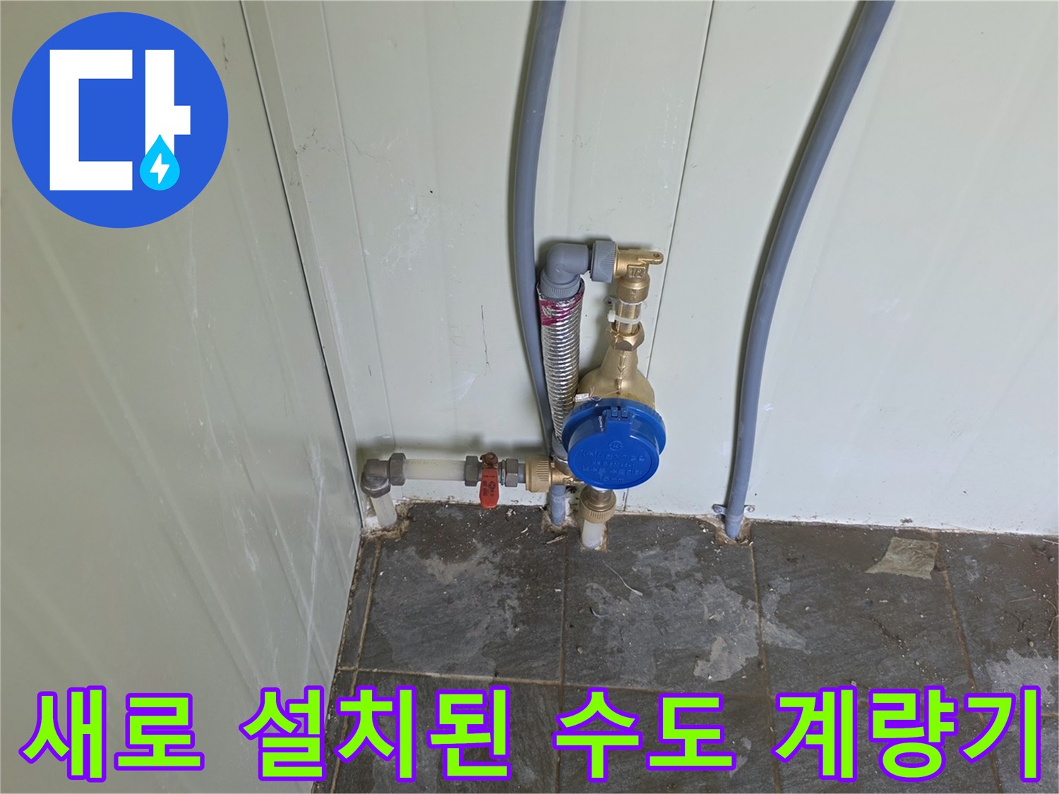 화장실 벽면에 설치된-파란색 캡의 수도 계량기와 배관 연결 부위