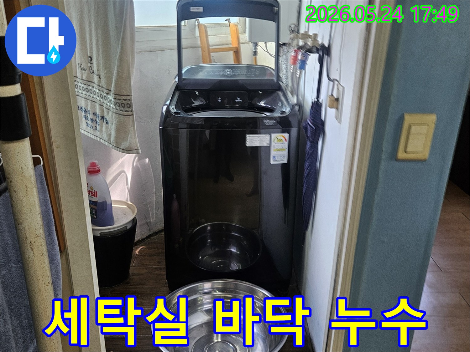 세탁기 옆에-놓인 양동이가-물이 새는-현장을 임시 조치한-사진