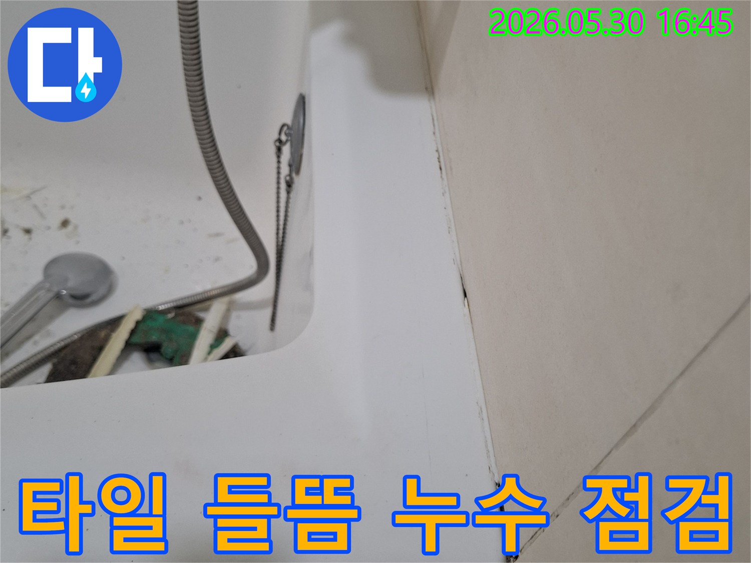 광명시 아파트 욕실에서-타일 들뜸으로 인한-누수 문제를-점검하고 있는-전문가의 작업 현장입니다