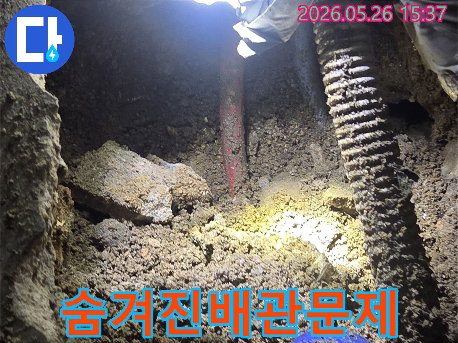 누수-전문가가-어두운-굴착-현장에서-손전등으로-숨겨진-배관-문제를-정밀하게-확인하는-과정