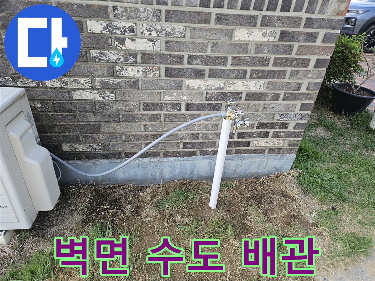 벽돌 구조물에 연결된 외부 급수용 파이프와 부속품