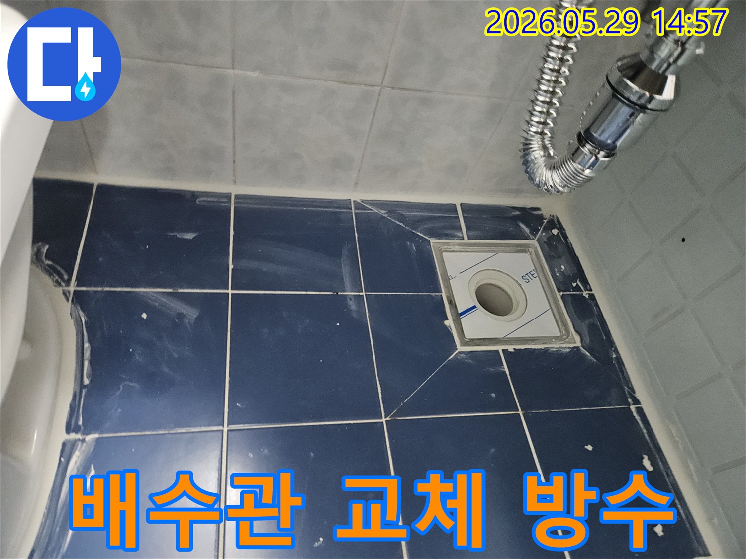 새로운 배수구와-주변 타일-그리고 유연한 배수관이-깔끔하게 설치된-욕실 바닥의-누수-공사-마무리-사진입니다