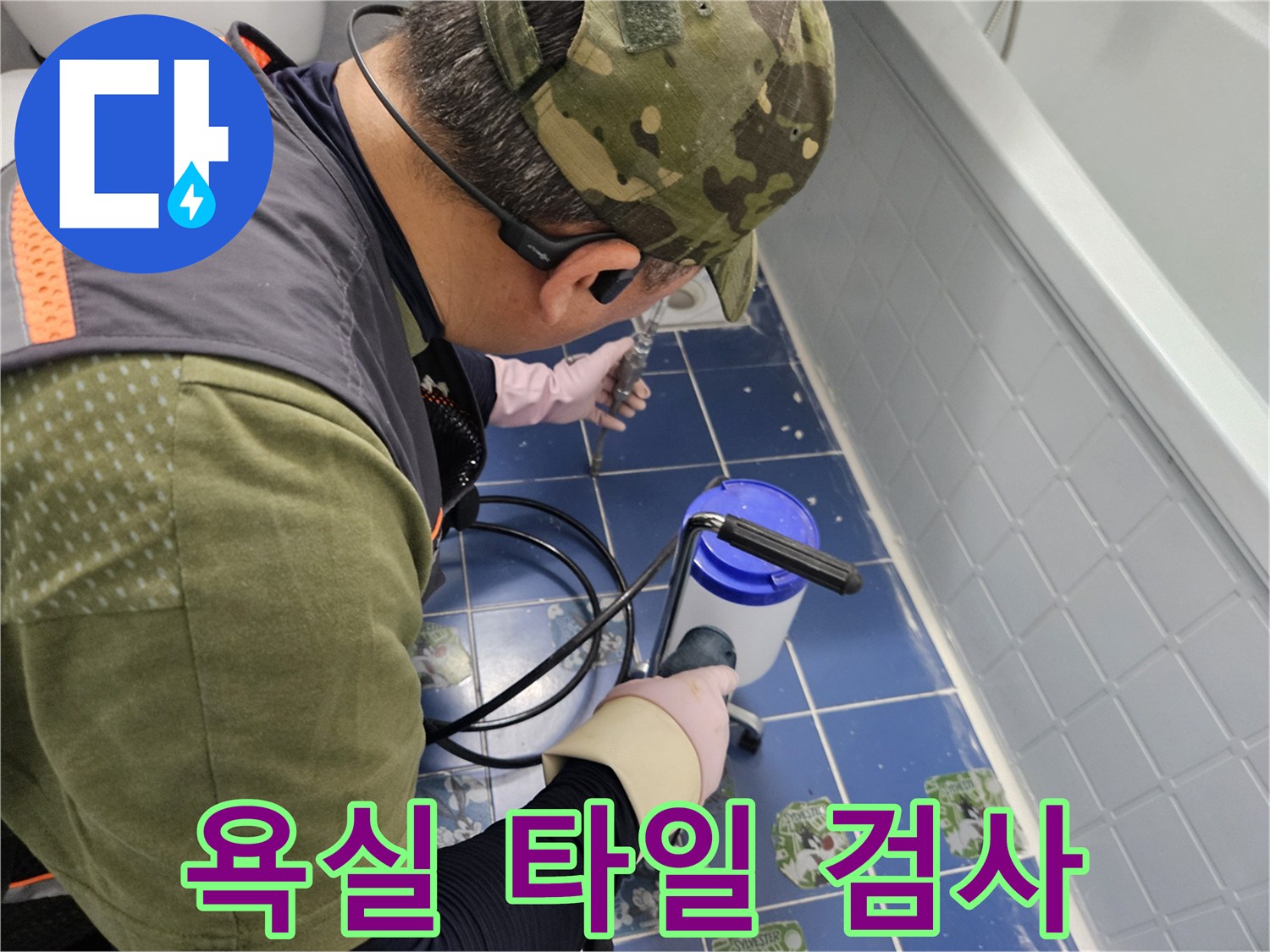 파란색 타일 위에서 장비를 사용하여 누수 여부를 진단하는 엔지니어