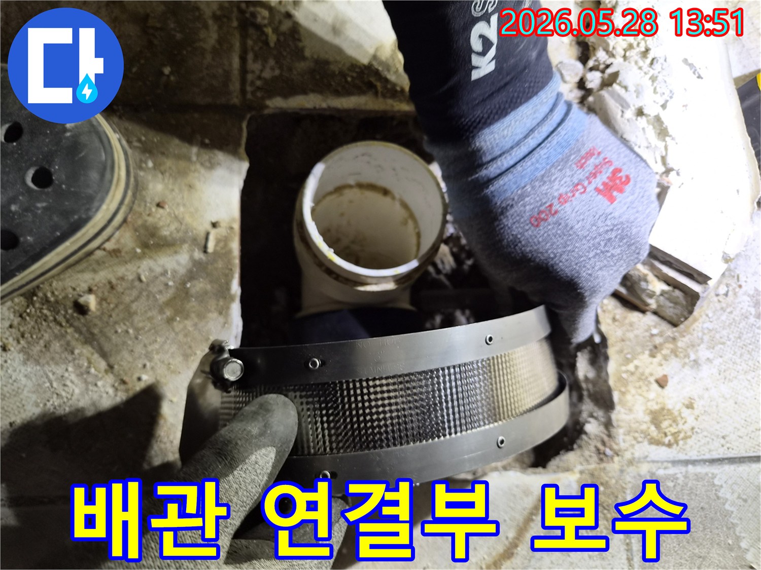 숙련된 작업자가 보호 장갑을 착용하고-빌라 배관의 연결 부위에-보강 밴드를 꼼꼼히 설치하는 중입니다