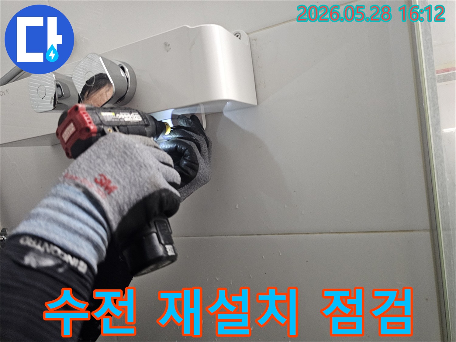 전문 기술자가-보호 장갑을 착용하고-전동 공구로-샤워기 수전의-재설치 후-누수 여부를-최종 점검하는-모습입니다