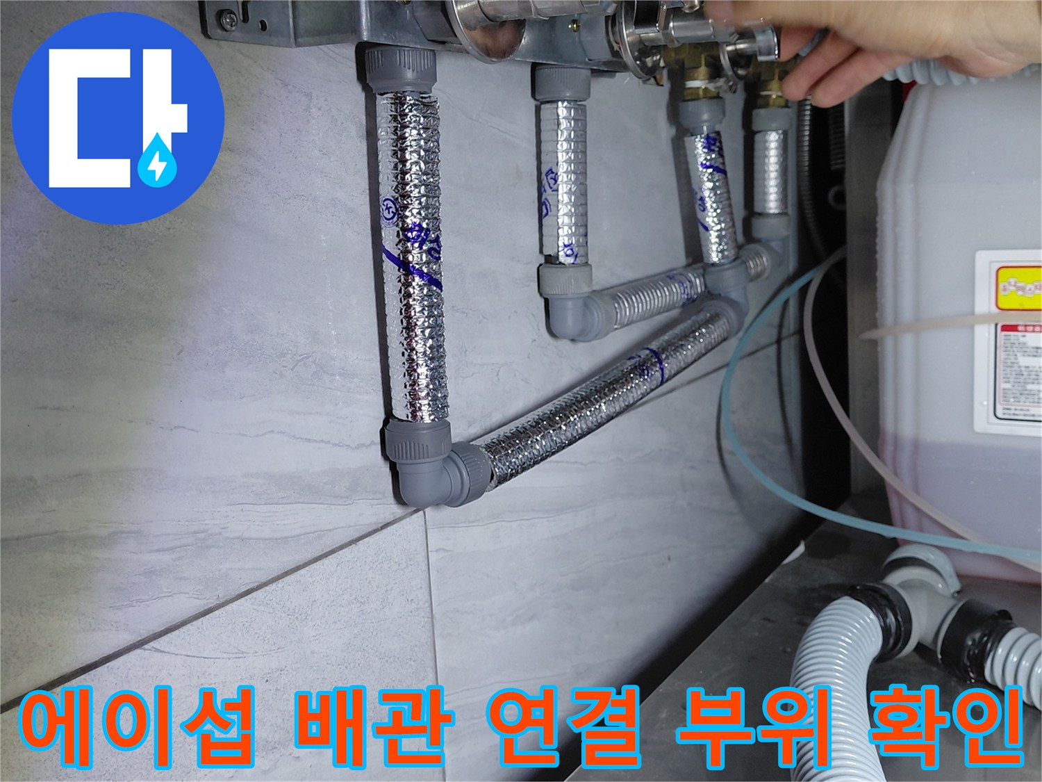 작업자가 에이콘 배관의 금속 연결 소켓 부분을 점검하는 사진