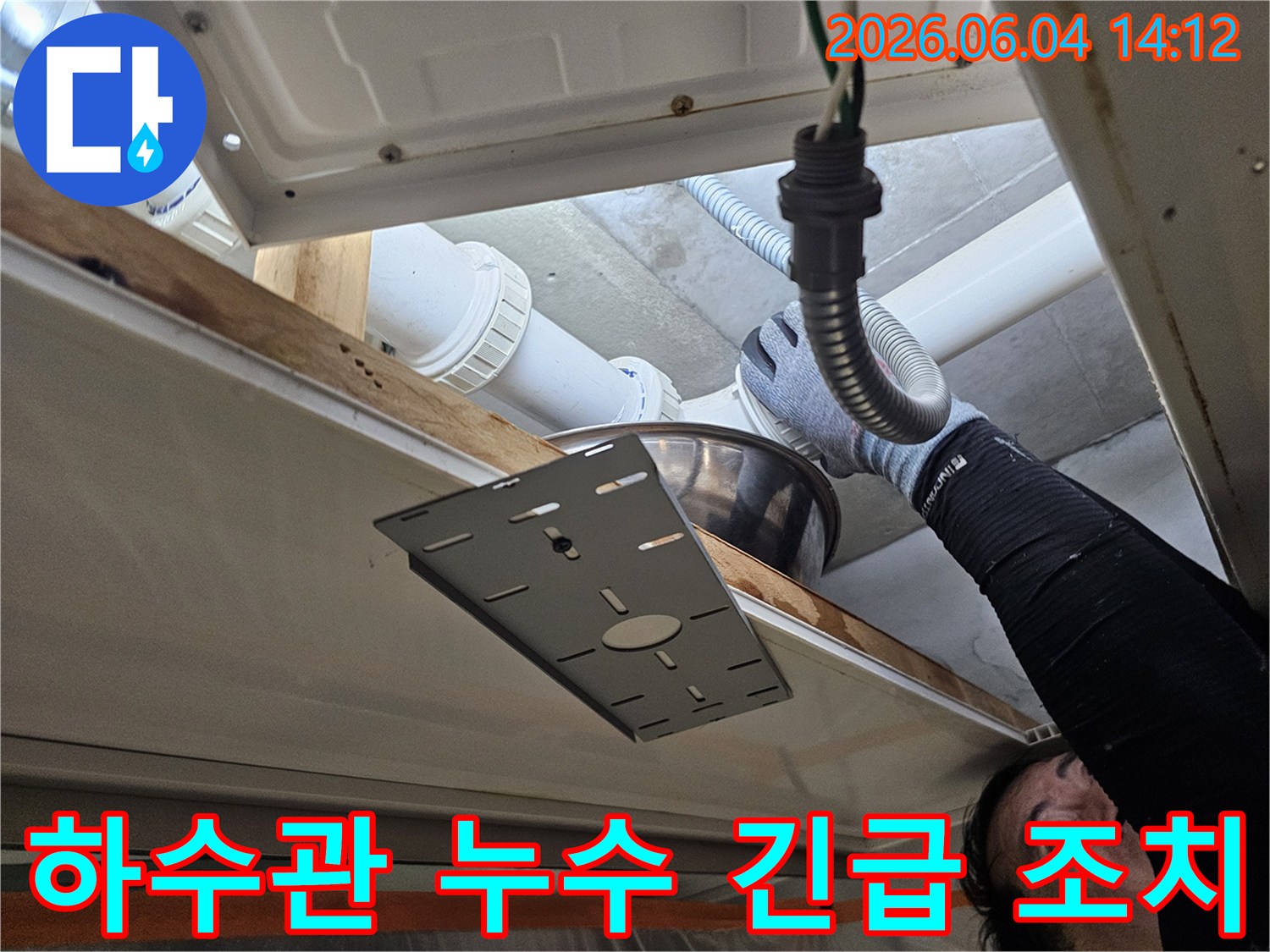 숙련된 기술자가-욕실 천장 하수관의-누수 지점을 확인하며-임시 조치를 취하는 장면입니다