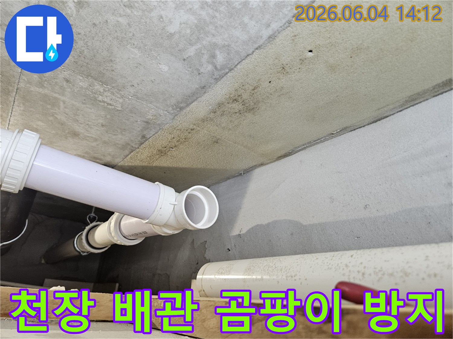 콘크리트 천장 아래에 설치된 PVC 배관 주변에-누수로 인한 광범위한 곰팡이와-오염이 발생한 현장 이미지