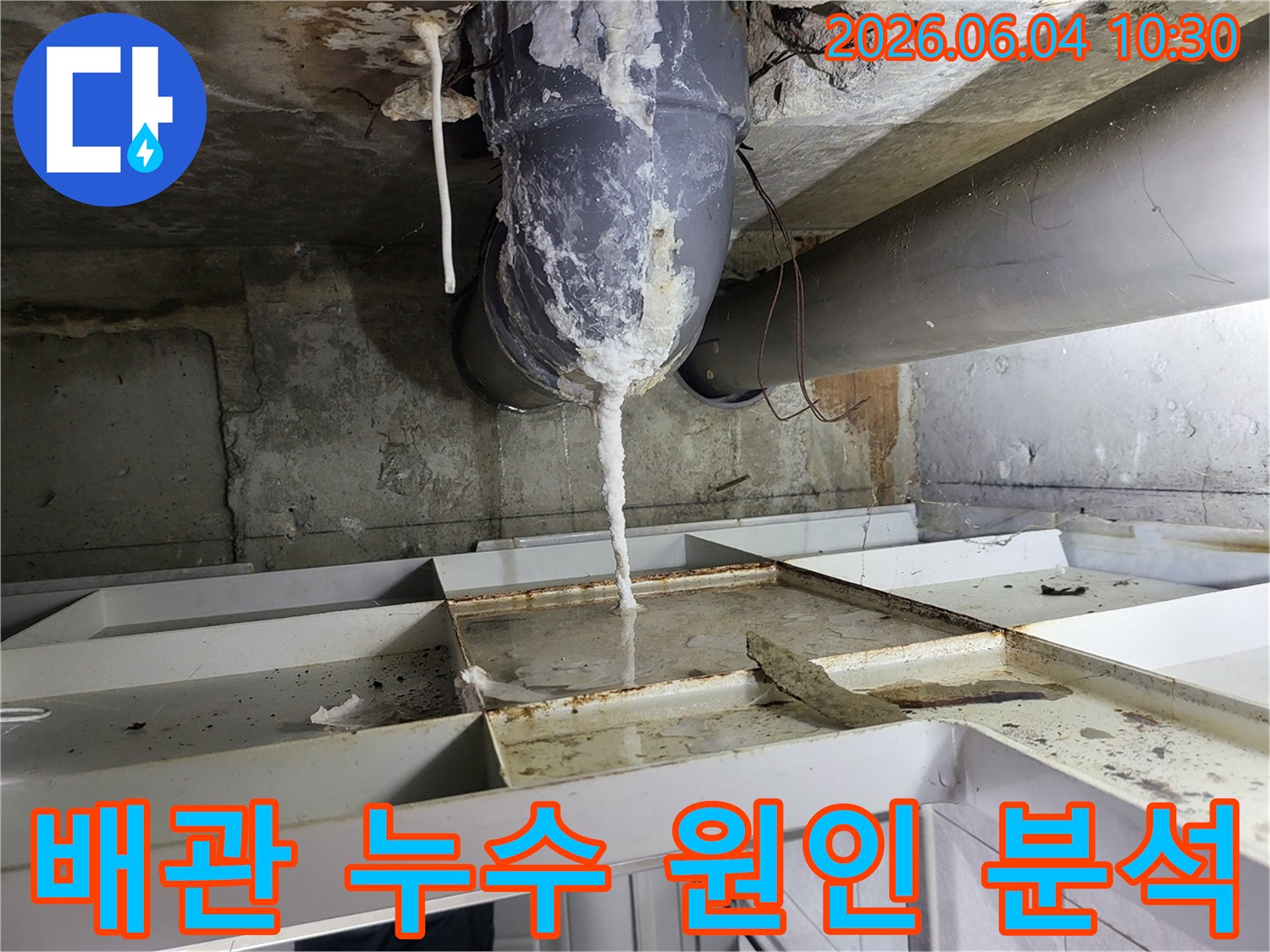 천장 배관에서 물이 새어 나와-석회질이 고드름처럼 맺히고-아래 바닥에 물이 고인 누수 현장