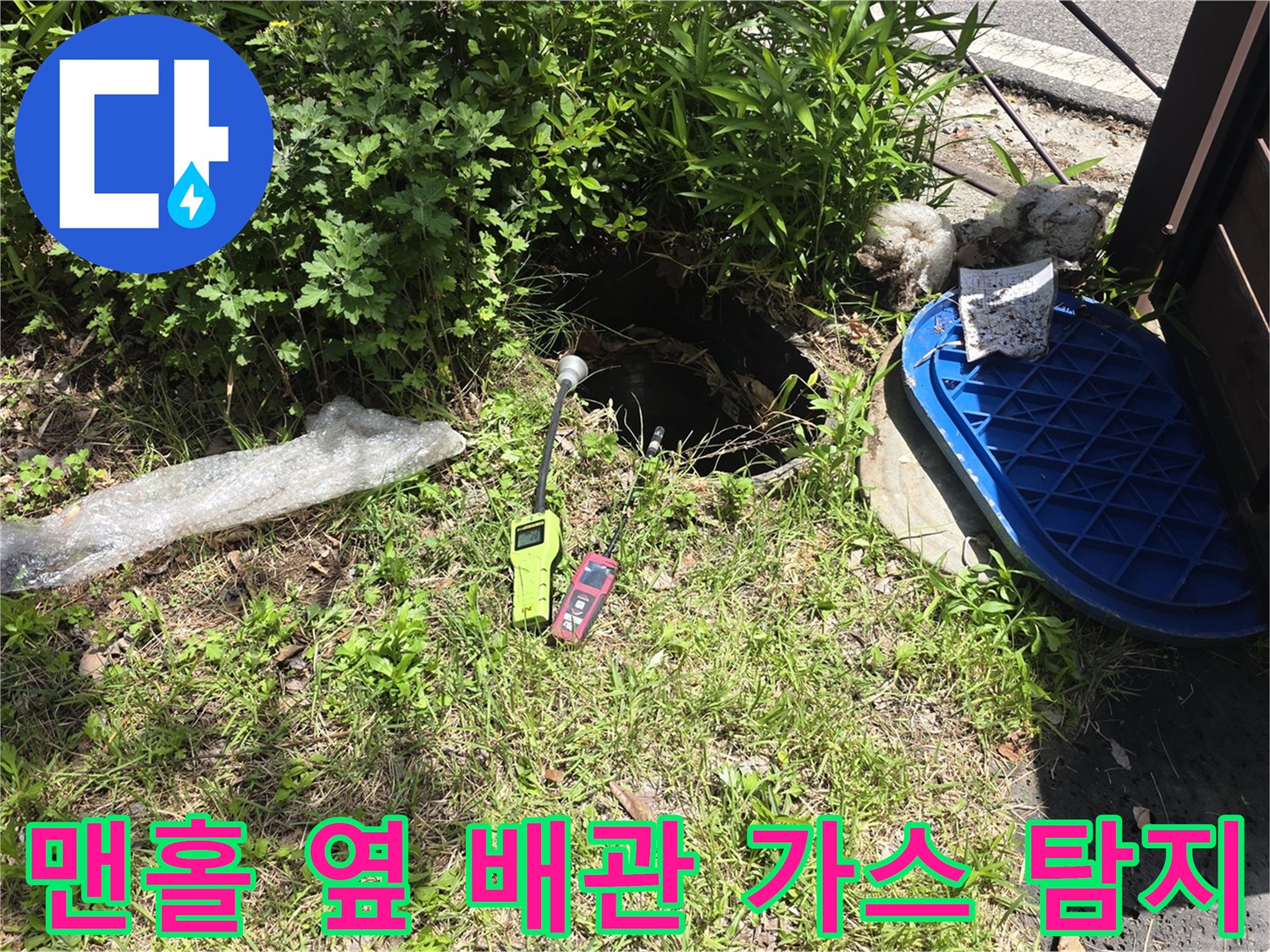 외부 점검구 주변의 젖은 토양과 배관 누수를 찾는 가스 탐지 장비