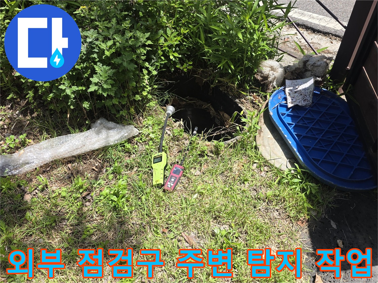 파란색 덮개와 가스 탐지기가 놓여 있는 외부 배관 점검 현장입니다.