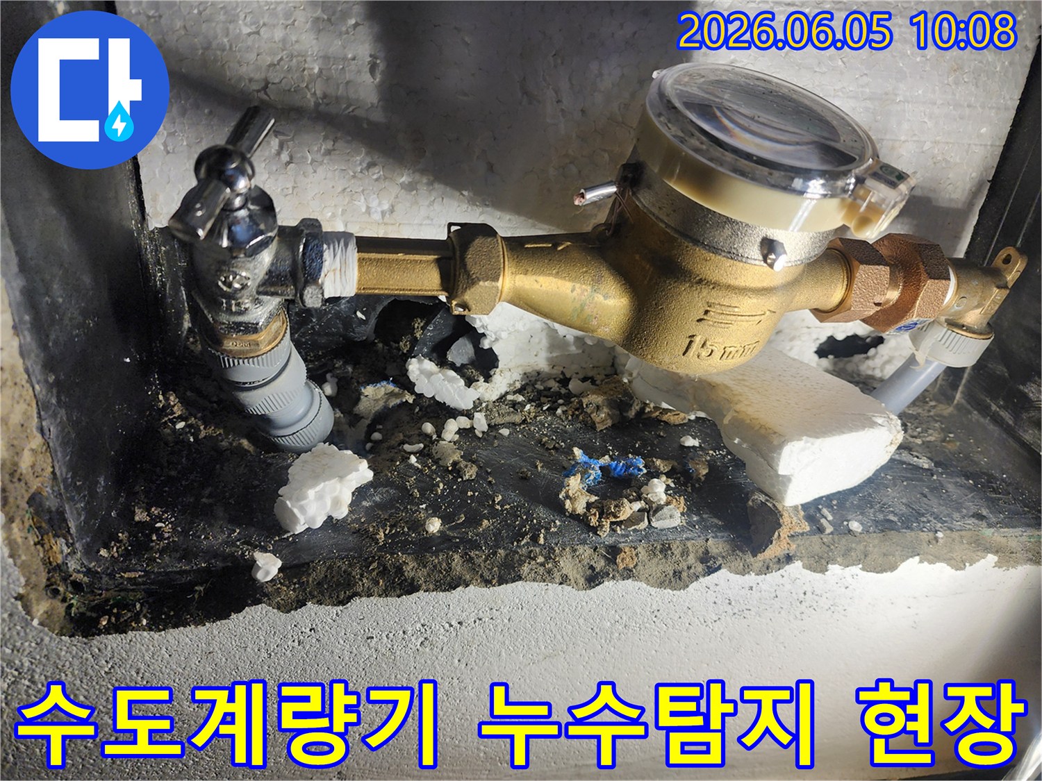이 사진은 수도계량기 주변에서 발생한 누수를 정확하게 진단하고 해결하기 위해 진행된 공사 현장을 보여줍니다-배관 연결부위-누수 흔적-수도관 수리