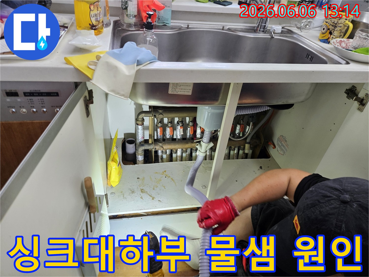 누수-전문가가-싱크대-아래-어두운-공간에서-누수-원인을-파악하기-위해-배관을-면밀히-살피고-있습니다