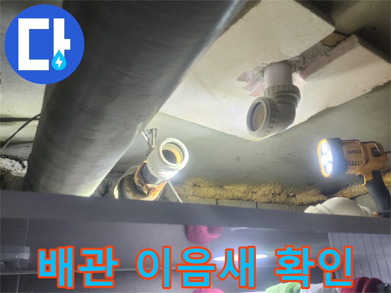 누수-전문가가-어두운-천장-속-배관의-이음새-부분을-집중적으로-확인하며-누수-여부를-판단하는-장면