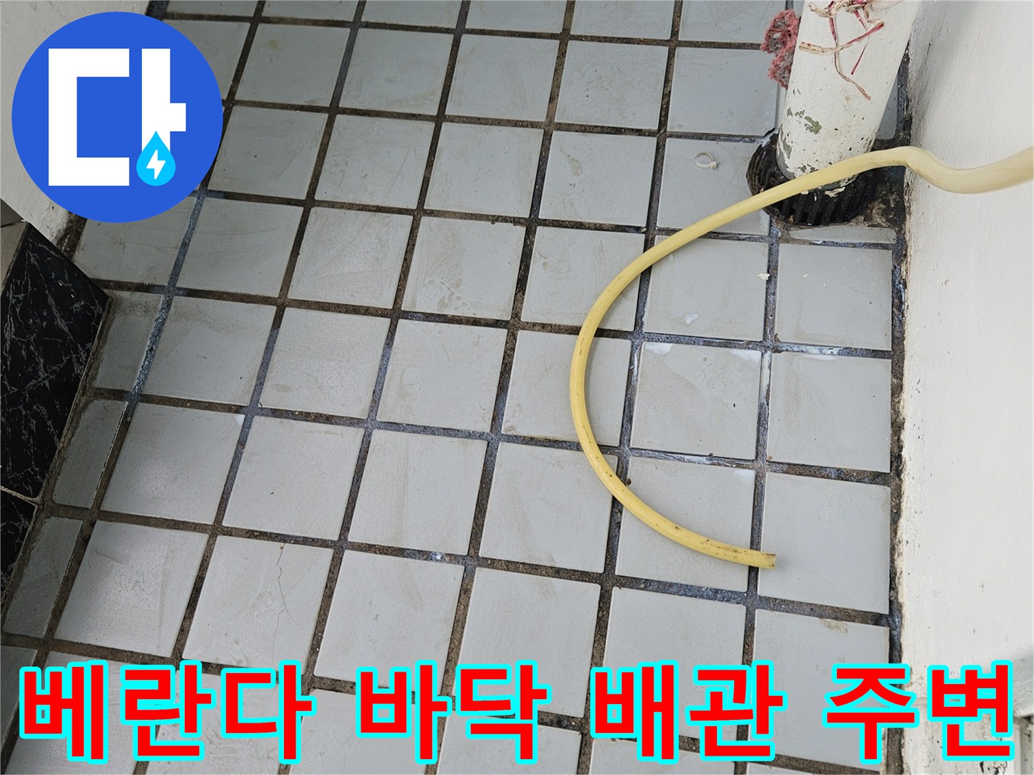 배수관과 타일 경계의 노후된 상태를 보여주는 사진입니다.