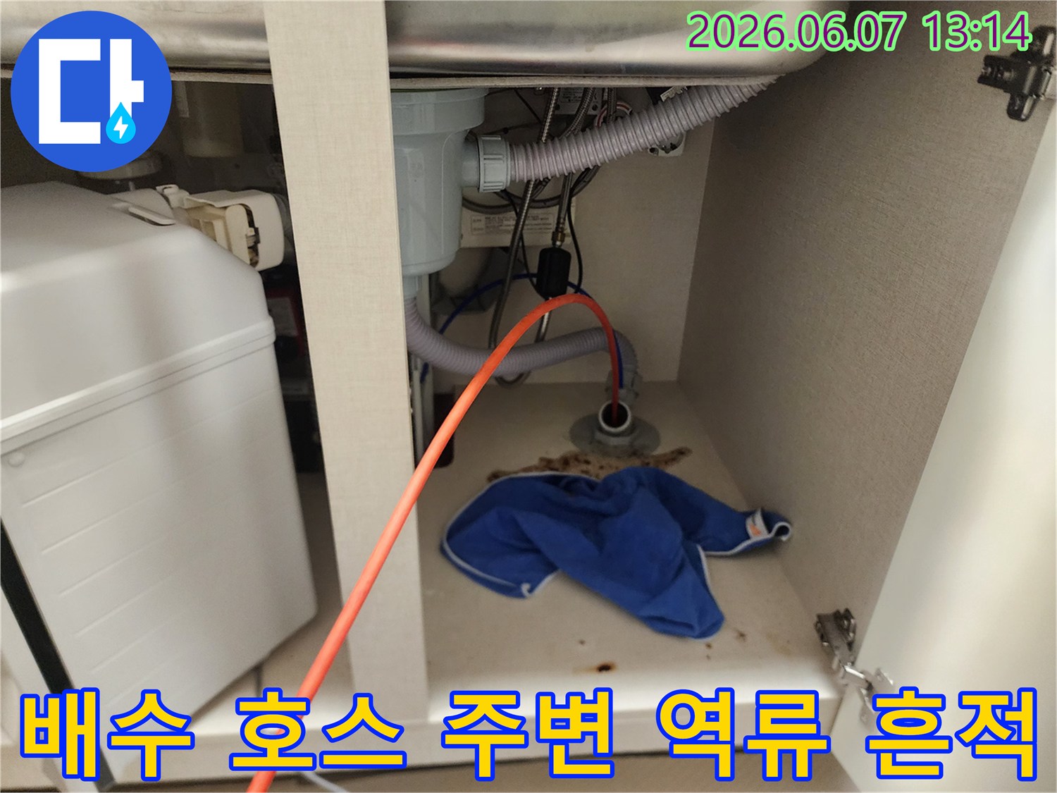 싱크대 하부 배관 연결 부위에 오염된 이물질과 걸레가 놓여 있습니다.