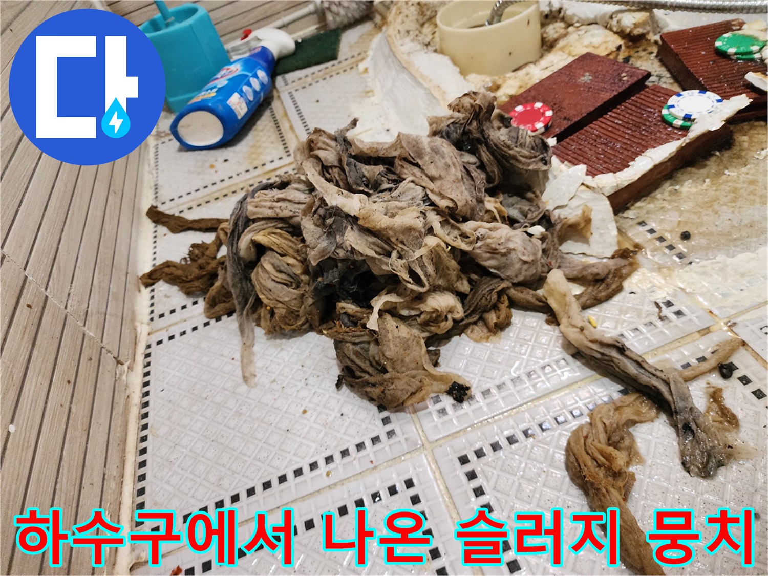 욕실 타일 바닥에 널브러진 머리카락과 기름때가 섞인 오염물질