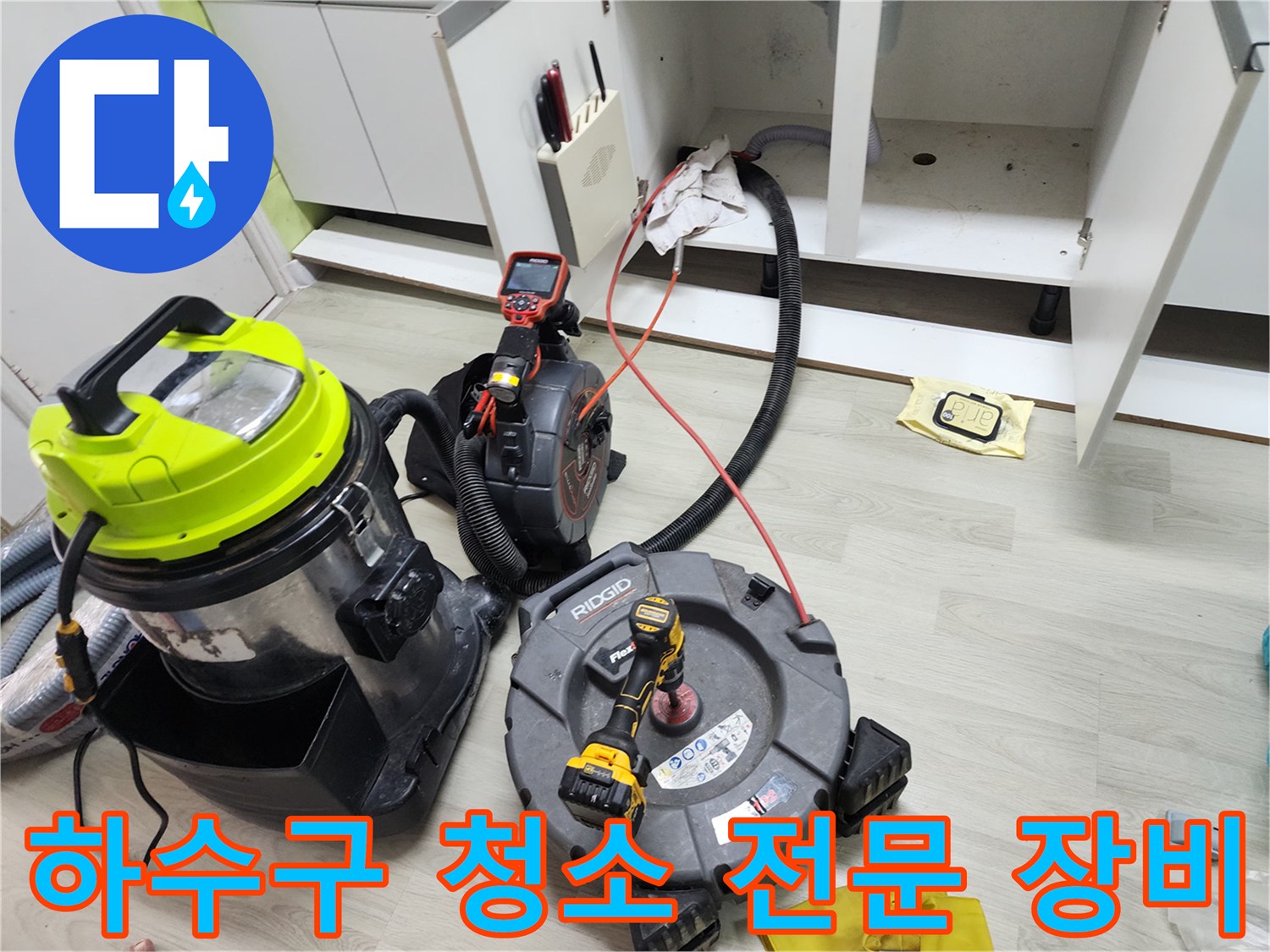 석션기와 배관 스케일링 기계가 놓여 있는 싱크대 하부 작업 현장