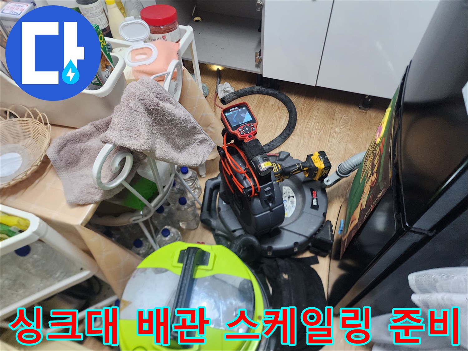싱크대 아래 배관 작업을 위해 배치된 석션기와 드릴 장비 세트