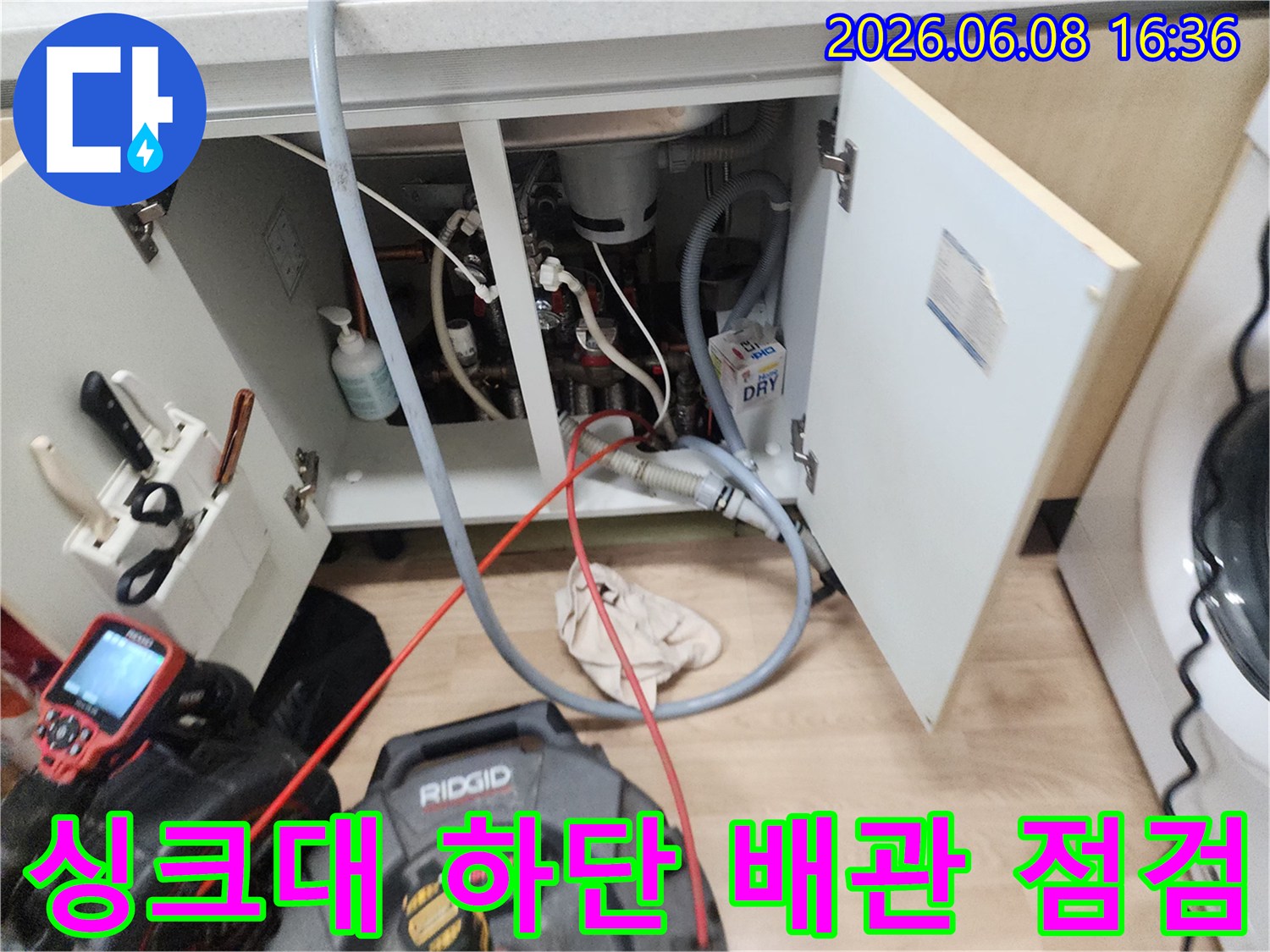 남양주 평내동 싱크대 하부장 내부의 복잡한 배관과 작업 장비 모습