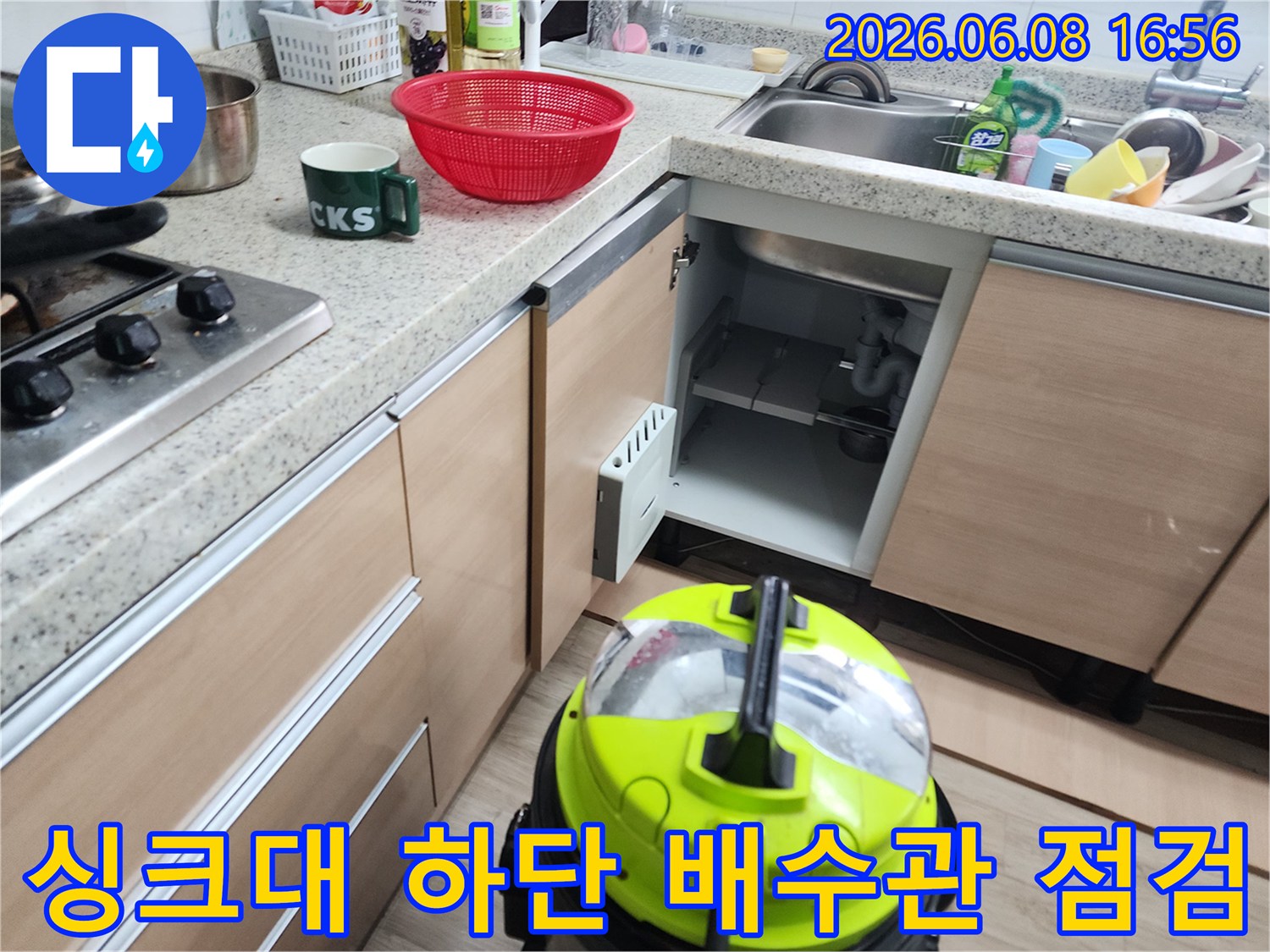 싱크대 아래쪽 배수 트랩과 석션 장비가 놓여있는 작업 현장입니다.