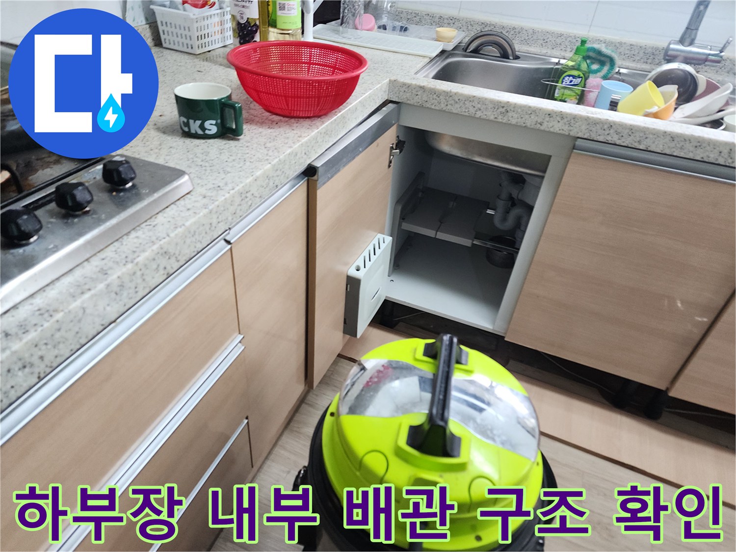 싱크대 아래쪽 분리된 배관과 작업용 석션 장비의 모습