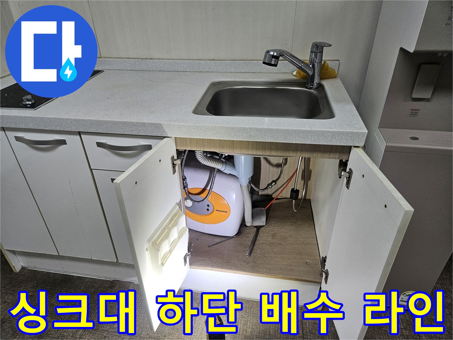 싱크대 아래쪽 수납 공간 내부의 세탁기 관련 배관 구조