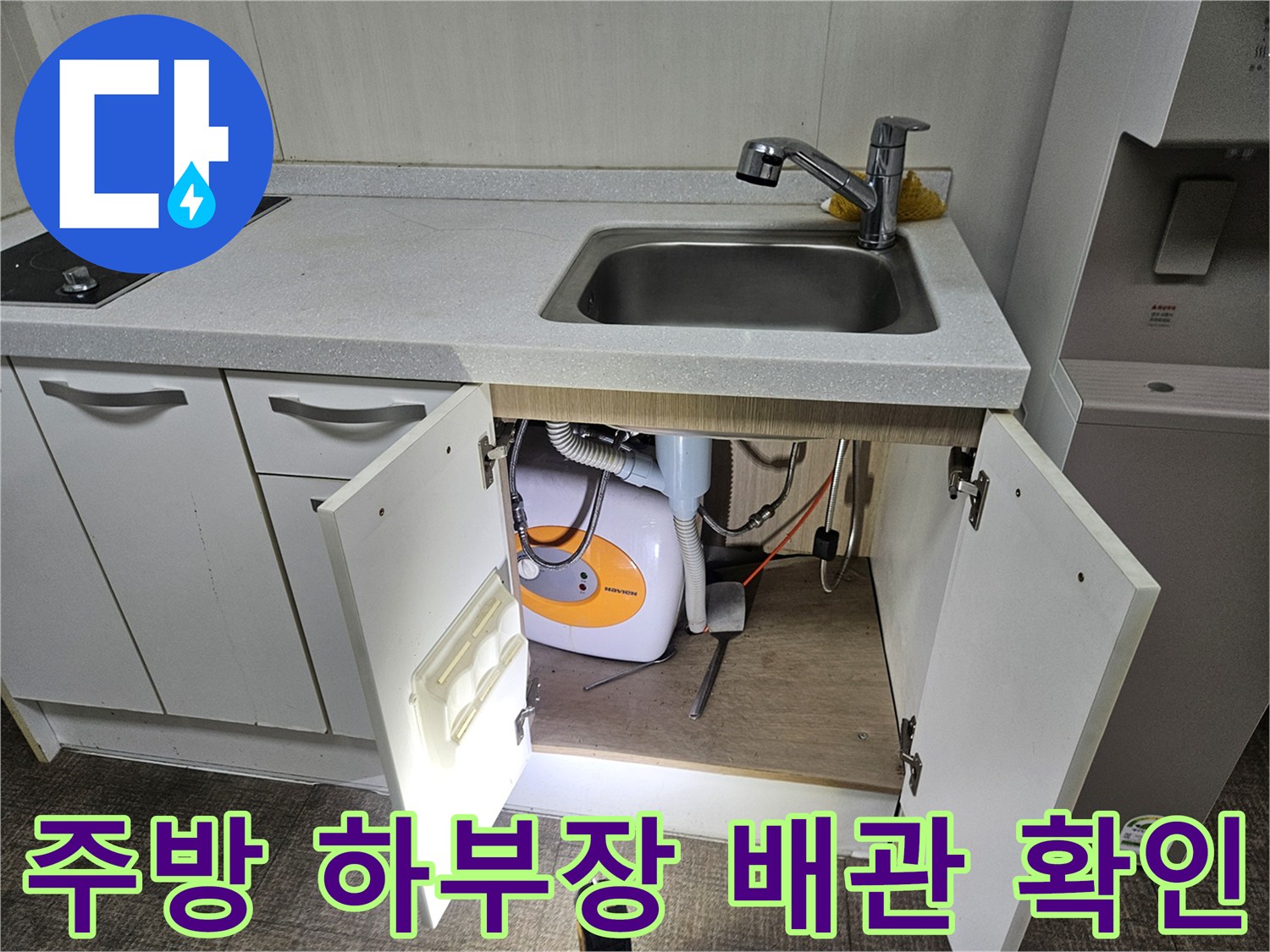싱크대 하단 수납공간 내 세탁기 연결 부위 근접 촬영