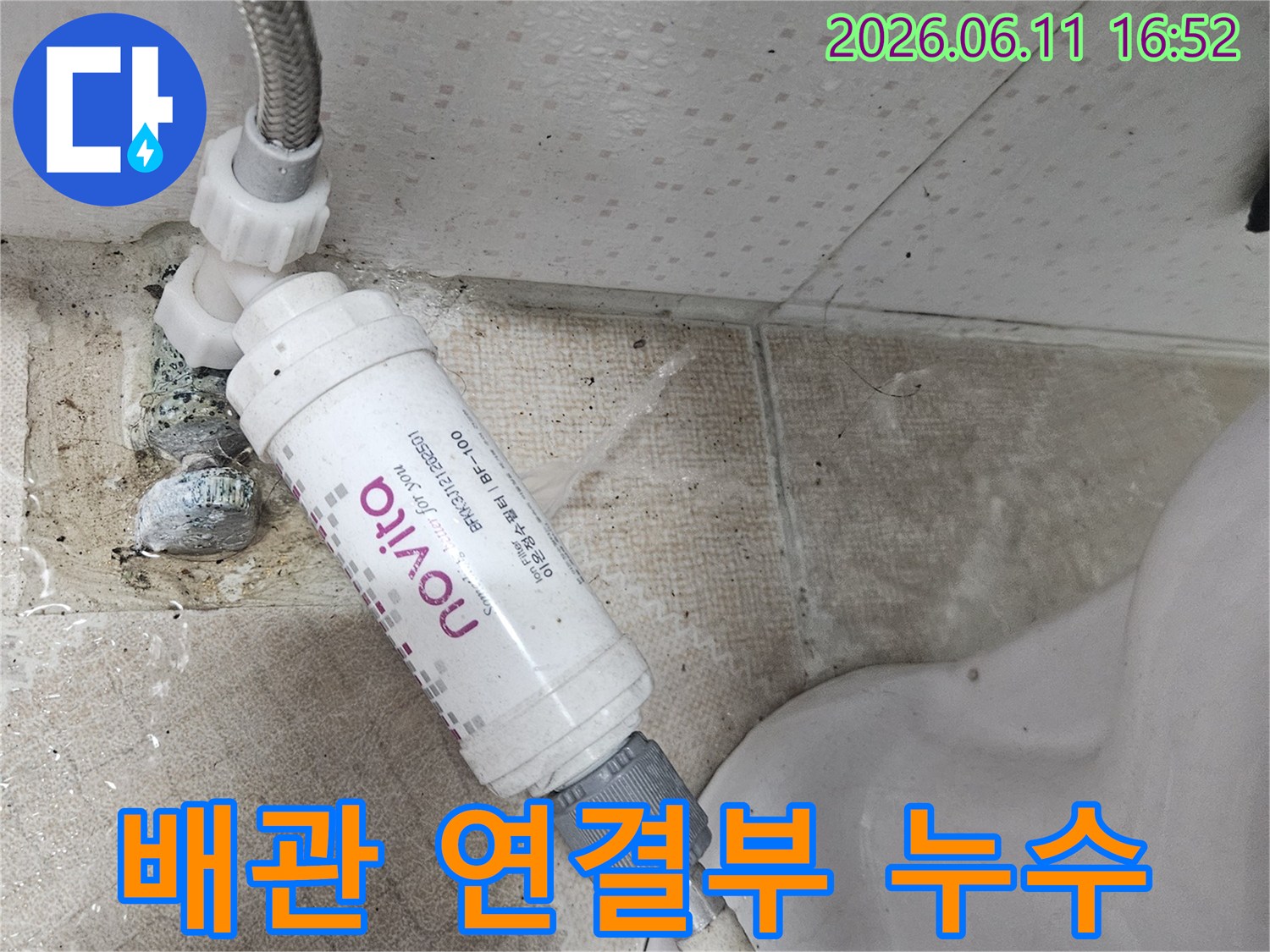 변기 옆 수도 배관과-정수 필터의 연결 부위에서-물이 새는 현장을-선명하게 보여주는 사진