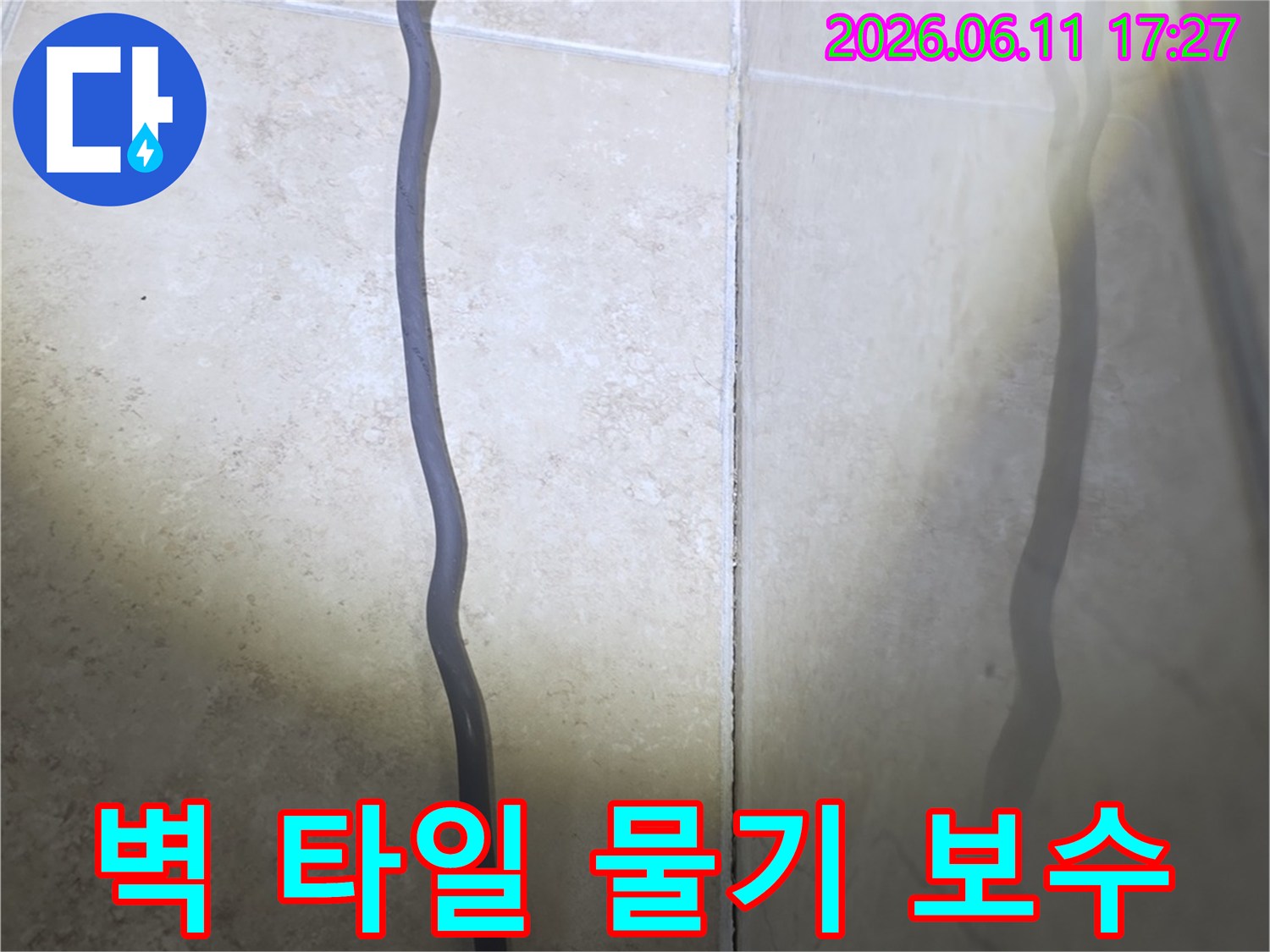 욕실 벽면 타일 하단부에-물이 스며들어 습기가 올라온 현장을 보여주는 사진입니다