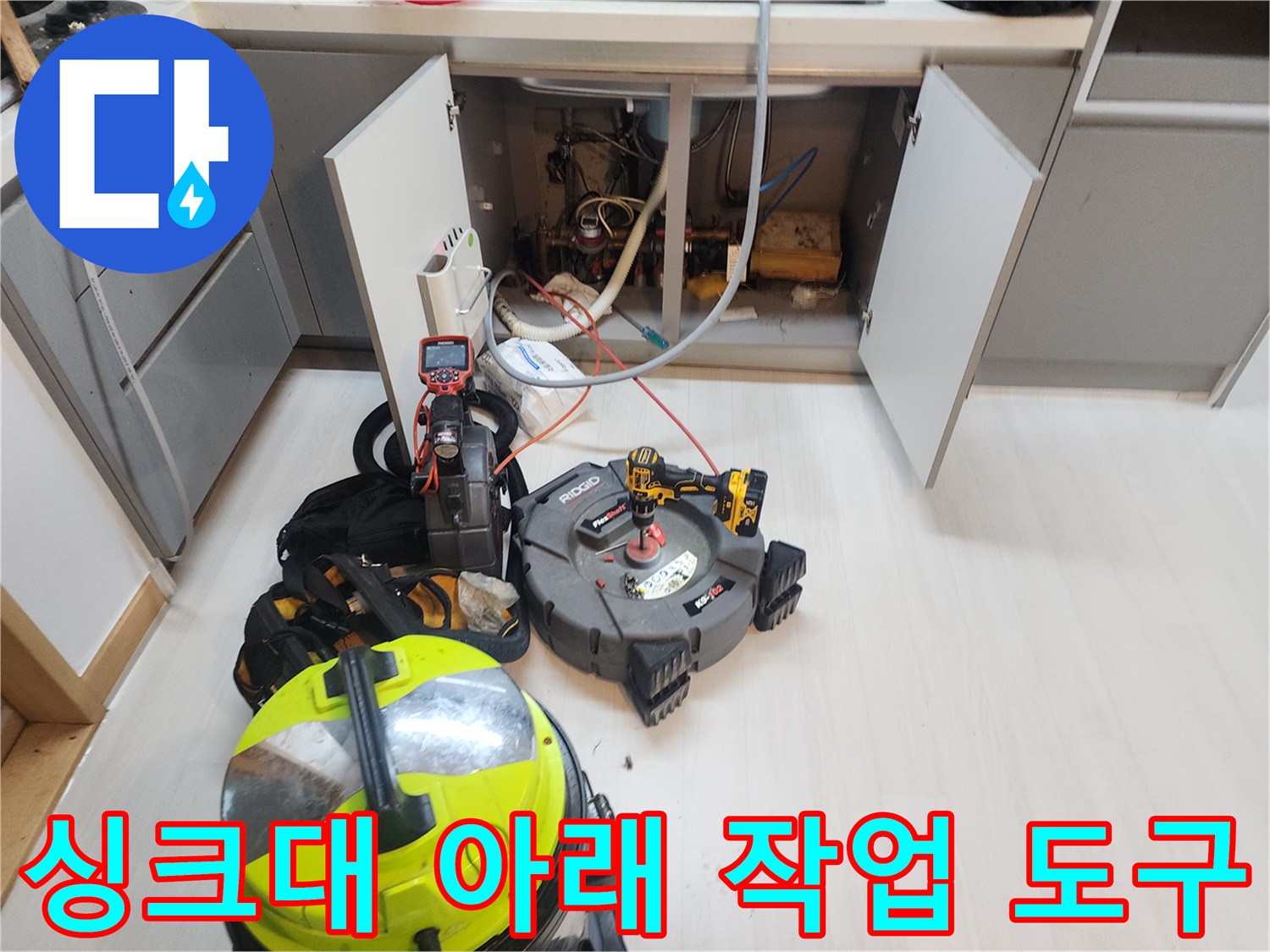 배수관 청소를 위해 싱크대 하단에 준비된 전동 드릴과 내시경 장비