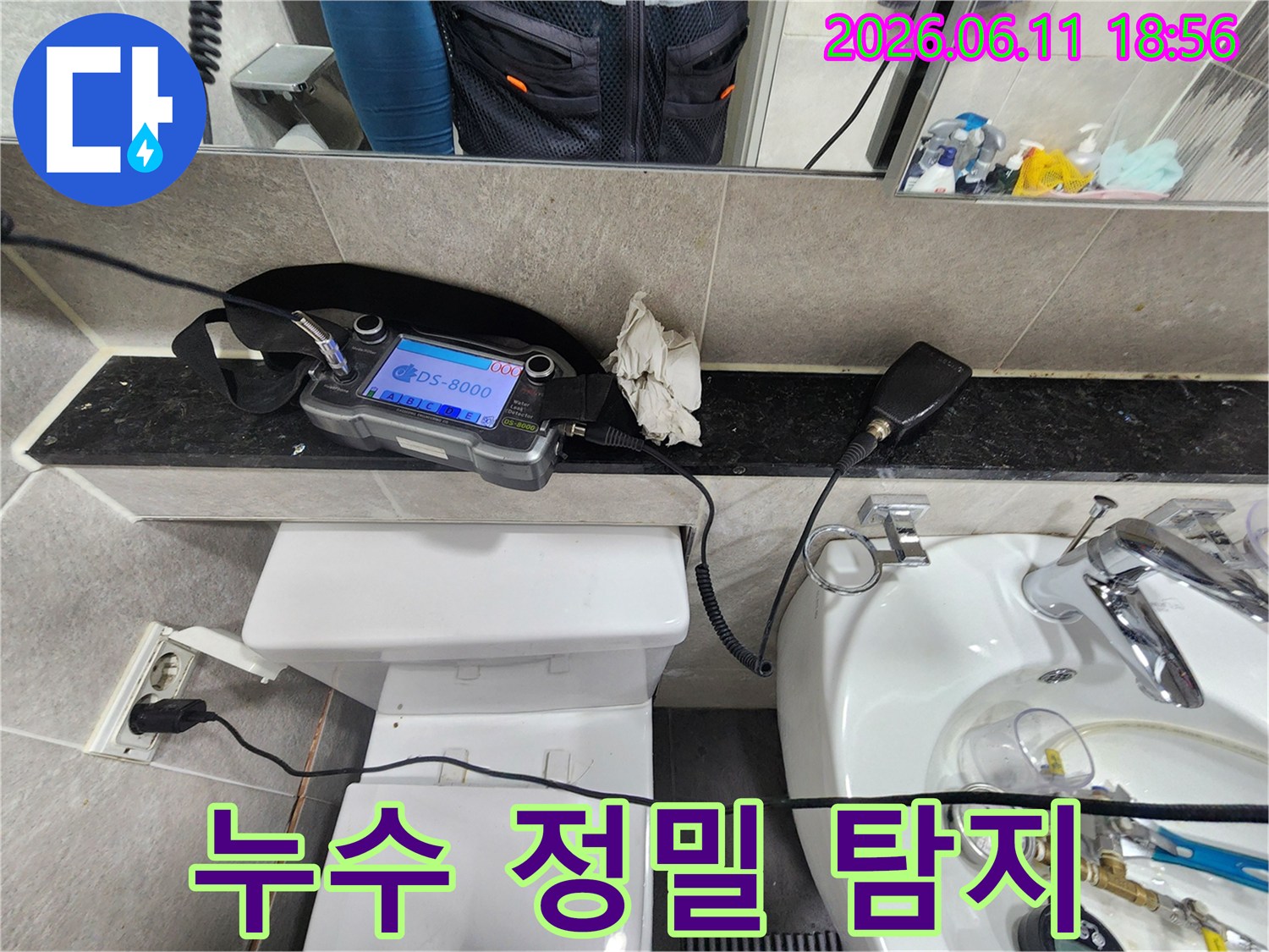 누수-엔지니어가-화장실-배관의-누수-지점을-정밀하게-탐지하기-위해-청음-장비를-사용하여-탐지하는-모습