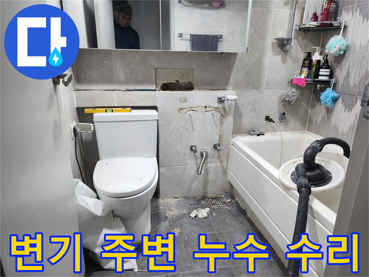 이 이미지는-동대문구 화장실에서-변기 주변에서 발생한 누수를 해결하기 위해-타일을 제거하고-배관 연결 부위를 점검하는-수리 현장을 보여줍니다