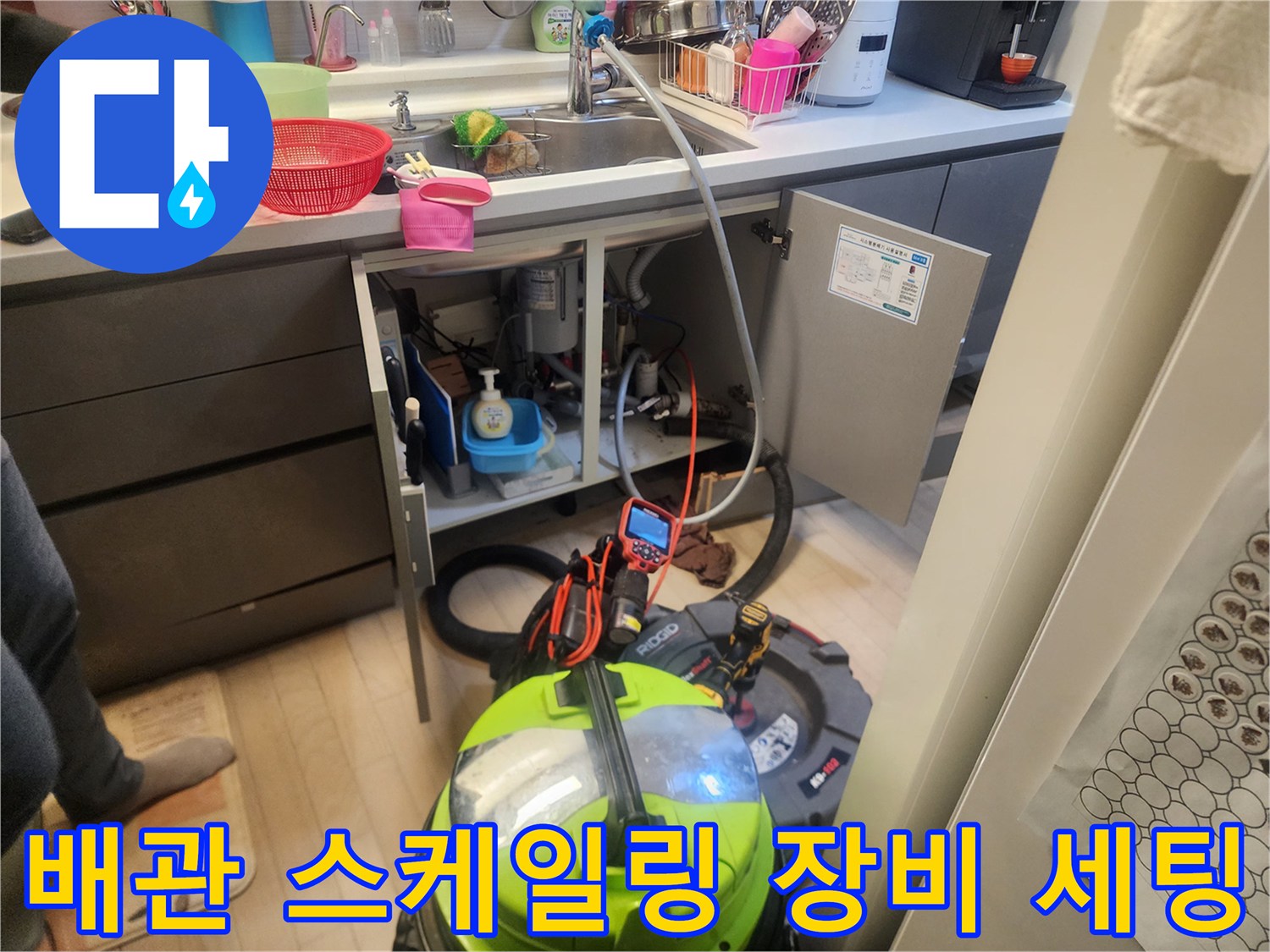 싱크대 밑 배관 내부를 청소하기 위해 준비된 석션기와 스케일링 장비