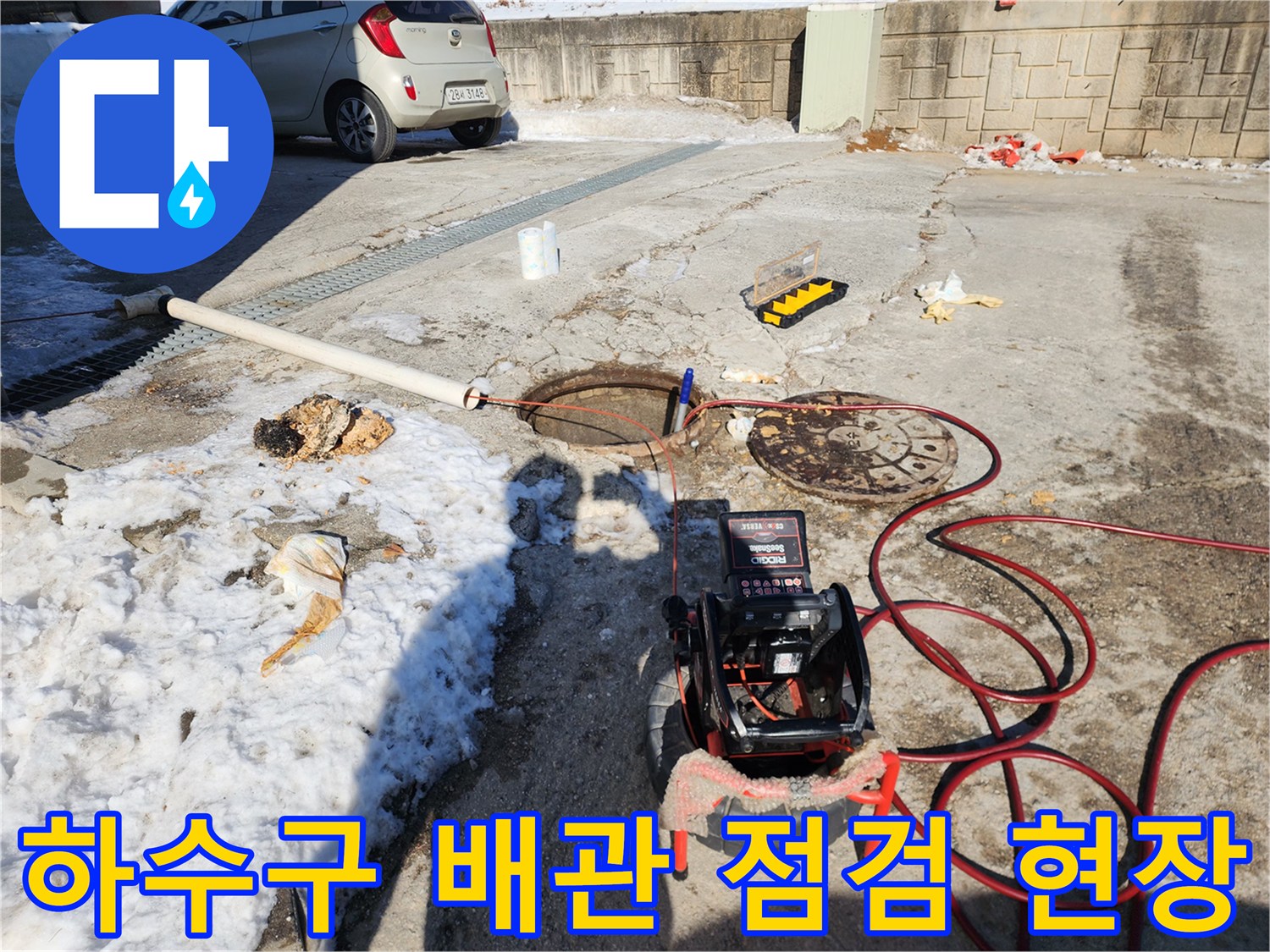 맨홀 뚜껑과 배관 주변에-배치된 전문 진단 장비 및 고압 세척용 호스