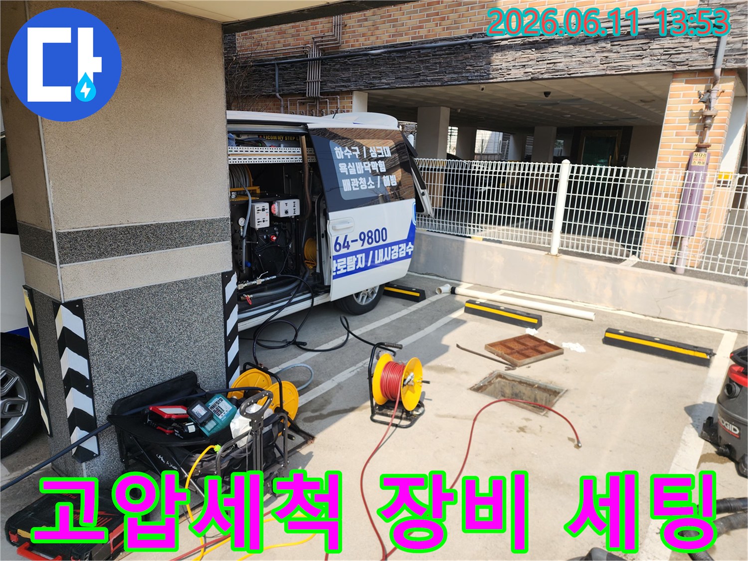 고압세차 차량 옆에 배치된 고압 세척 호스 릴과 전문 청소 장비들