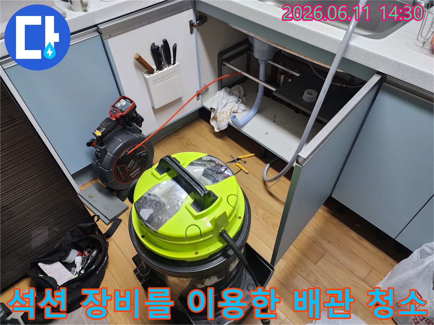 싱크대 하수관 내부의 이물질을 흡입하기 위해 준비된 석션기와 호스 연결 모습입니다.