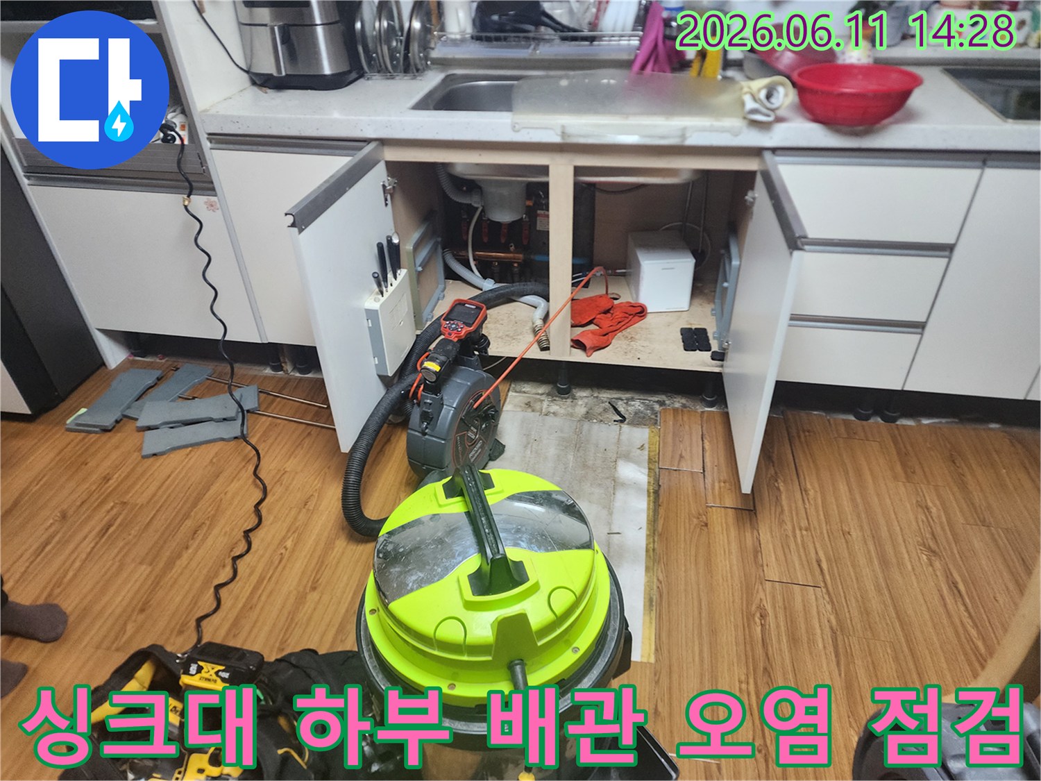 싱크대 아래쪽 배수관과 석션 장비가 놓여있는 작업 모습